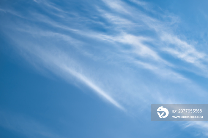 Bright blue sky background with cirrus clouds