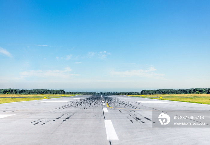 Empty runway at the airport on a sunny clear cloudless day.