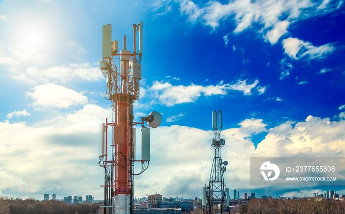 Panel antenna of GSM DCS UMTS LTE bands and radio unit are as part of communication equipment of basic station are installed on roof and blue sky as background