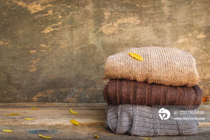 Pile of colorful warm clothes on wooden background. Toned image.