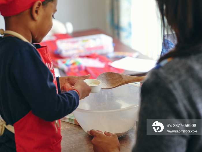 Mother and son baking in kitchen