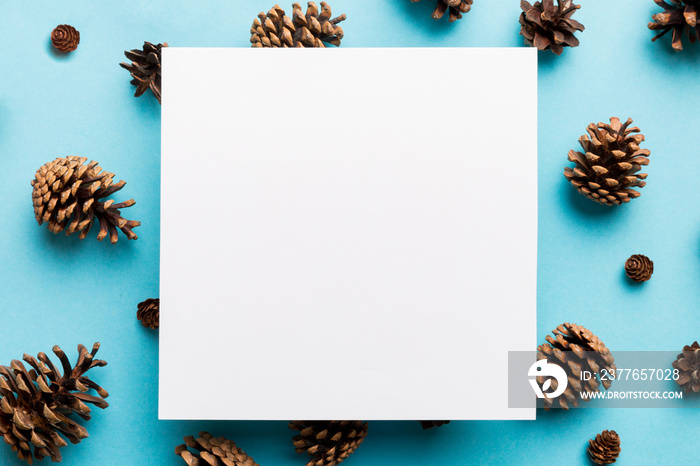 Creative frame made of Christmas pine cones with square Paper blank. Xmas and New Year theme. Flat lay, top view copy space