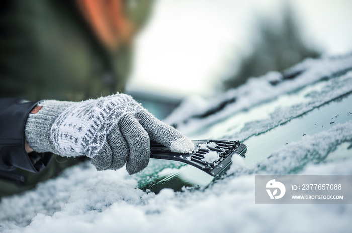 Clean car window from snow. Winter windshield car cleaning. Removing snow from window.