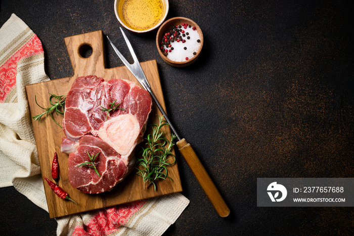 Raw beef steak osso bucco with herbs and spices on dark table. Marble meat. Top view and copy space