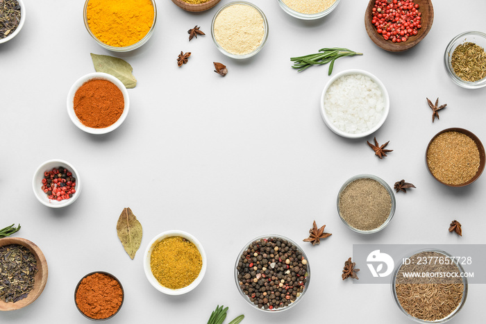 Frame made of bowls with spices on white background