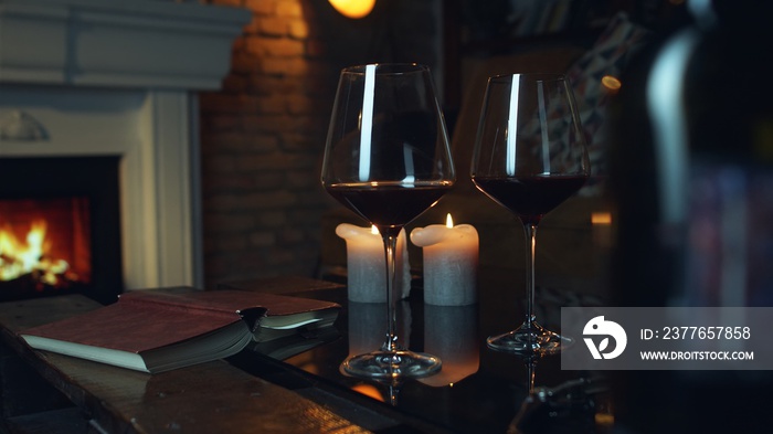 Wine, book and fireplace home in winter