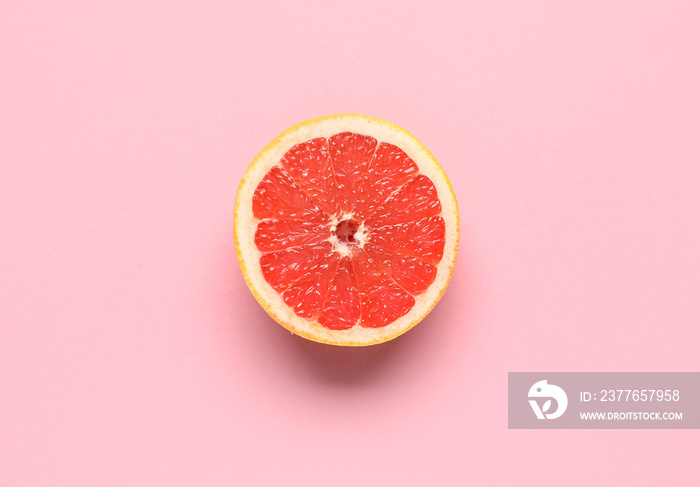 Tasty half grapefruit on pink background