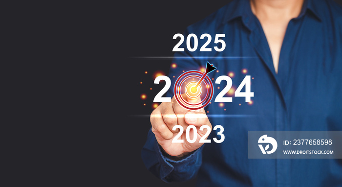 Businessman pointing to digital 2024 calendar on virtual screen while standing on a gray background