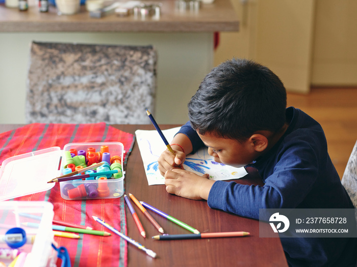 Boy drawing at table