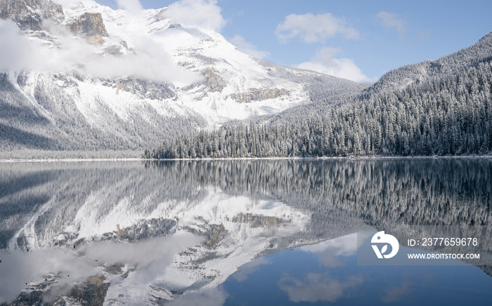 Still alpine lake reflecting its winter surroundings like a mirror, Yoho N. Park, Canada