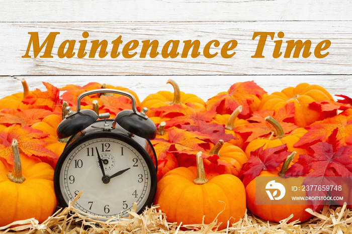 Maintenance Time message with a retro alarm clock with pumpkins and fall leaves