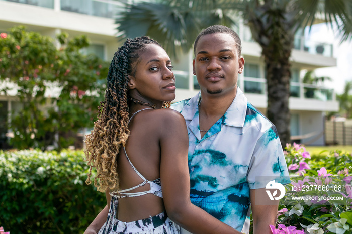 Young attractive black couple holding each other and looking at the camera. Jamaican couple.