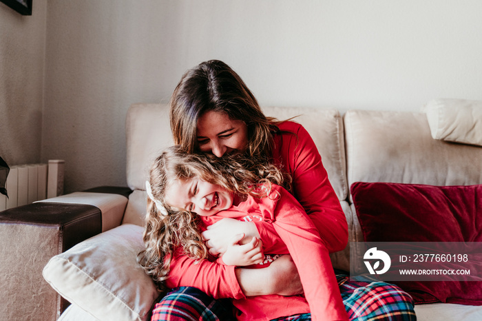 young mother and daughter playing at home. Christmas time