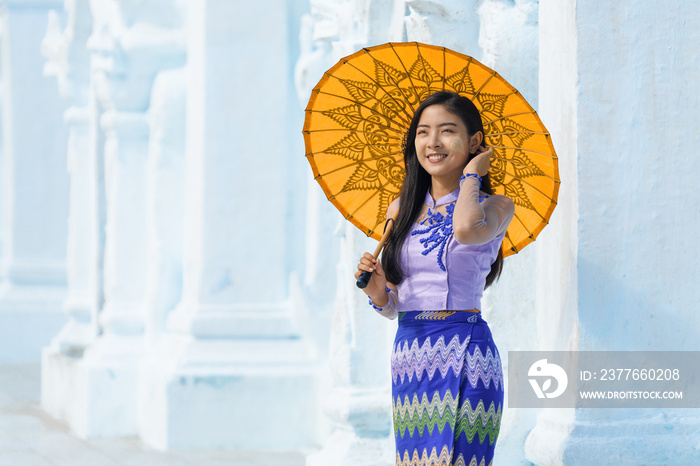 Myanmar Burmese woman with umbrella in Burmese traditional dress at Sandamuni pagoda in Mandalay