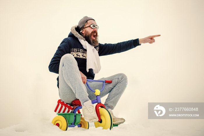 Crazy man riding bicycle on winter snowy landscape. Christmas and new year with fun.