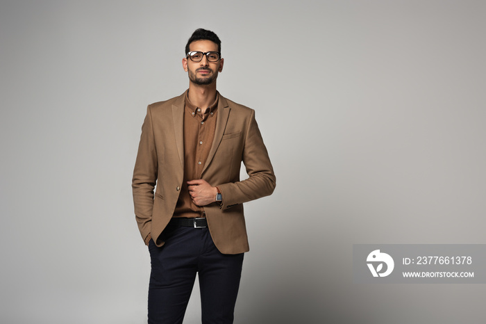 Arabian manager in brown shirt and jacket on grey background