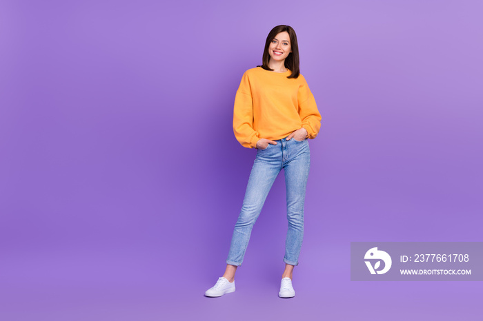 Full body length photo of pretty charming lady wear stylish new outfit denim jeans yellow sweater trend designer isolated on violet color background
