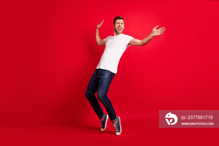 Full body portrait of excited handsome person look empty space partying isolated on maroon color background