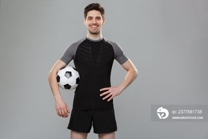 Portrait of a smiling young sportsman with a soccer ball