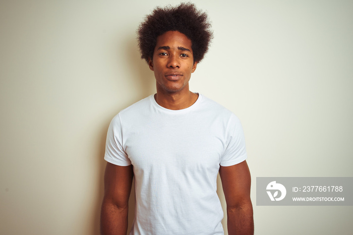 African american man with afro hair wearing t-shirt standing over isolated white background with a confident expression on smart face thinking serious