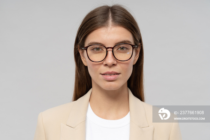 Headshot of smart confident businesswoman in glasses isolated on gray background