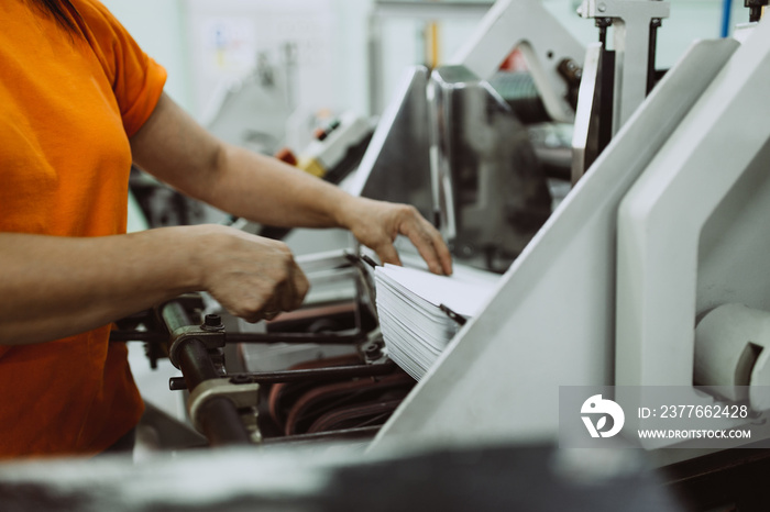 Close up shot of worker’s hand preparing carton for printing in a modern printing house.