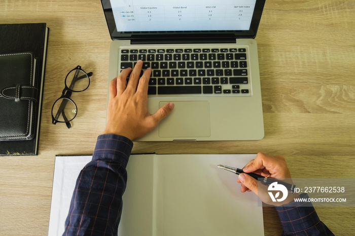 Businessman using laptop to the situation on the market value , Business concept