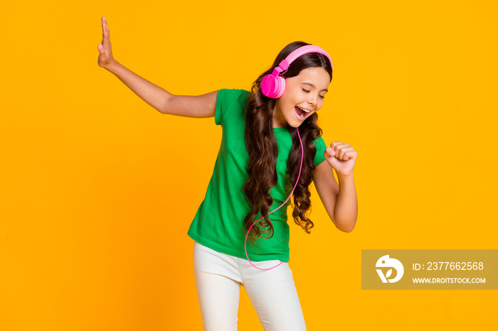 Photo of happy excited crazy smiling girl singing listen music in headphones isolated on yellow color background