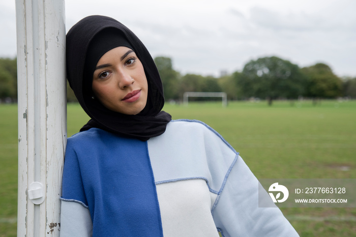 Portrait of woman in hijab standing in soccer field