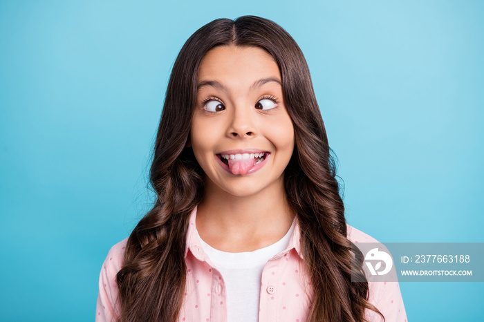 Portrait of carefree curly hairstyle school person show tongue squint eyes isolated on blue color background