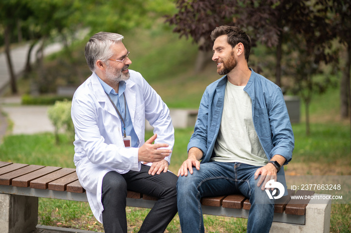 Male patient talking to his doctor and telling about symptoms