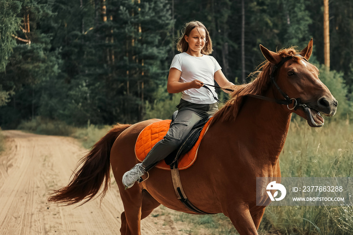 A girl rides a horse in the hot summer in the forest