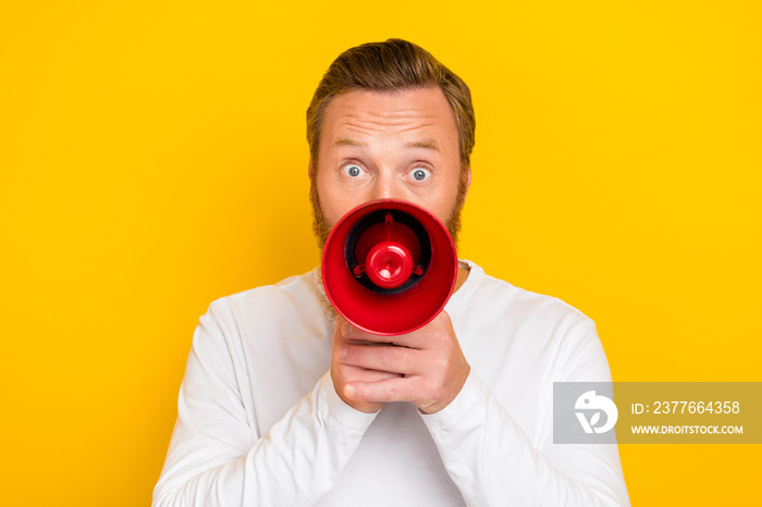 Photo portrait of nice young man hold megaphone announce shopping season promo wear stylish white look isolated on yellow color background