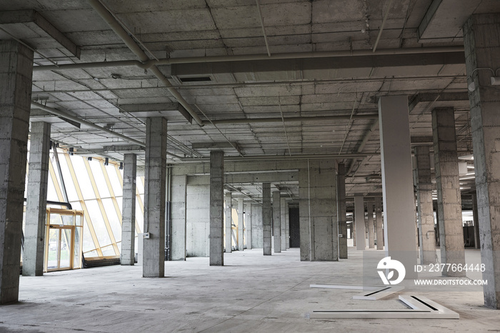 Wide angle background image of empty building under construction with concrete columns, copy space