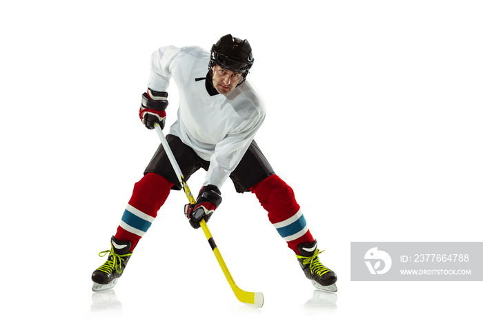 Speed. Young male hockey player with the stick on ice court and white background. Sportsman wearing equipment and helmet practicing. Concept of sport, healthy lifestyle, motion, movement, action.