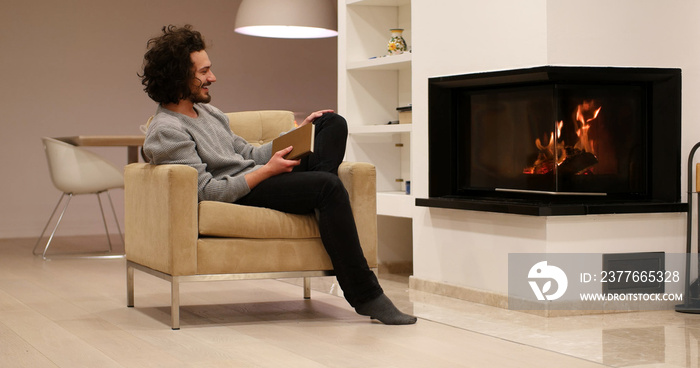 young man at home reading book