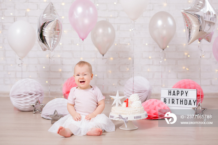 first birthday party concept - cute little girl crying with cake and balloons