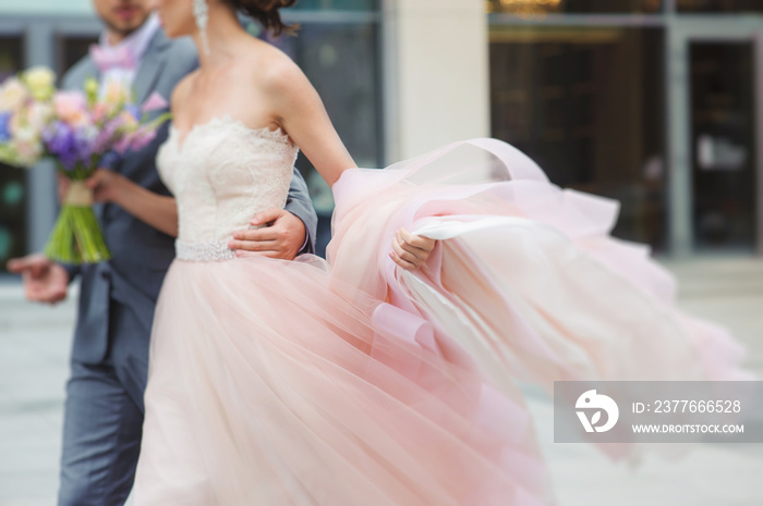 Luxury bride holding a flying dress and walking