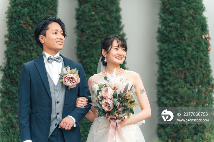 結婚式で結婚式場の庭でブーケを持つ新郎新婦（ガーデンウェディング）