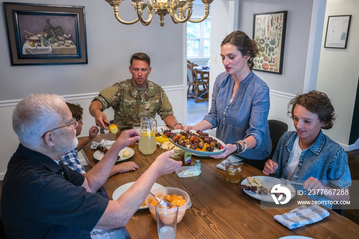 Air Force service member fixes and eats dinner with family.