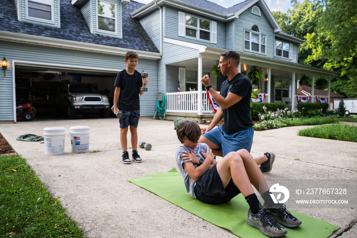 Air Force service member trains with his sons in a morning workout in preperation for a PT fitness test.