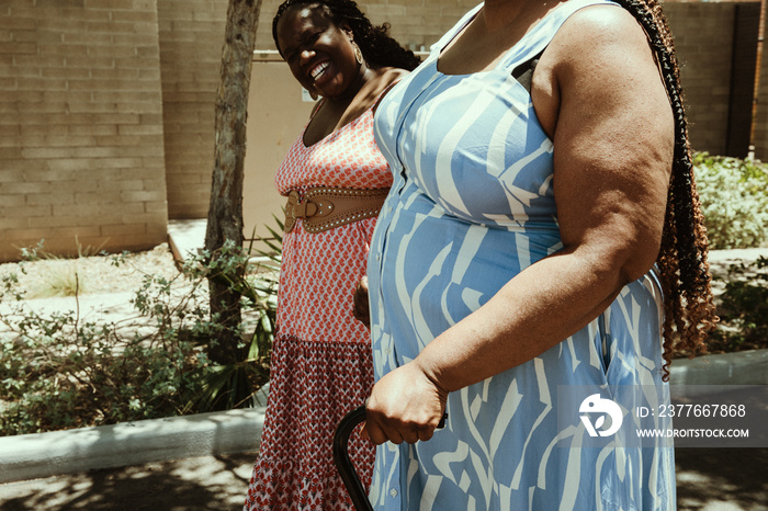 closeup of African American woman’s hand on cane walking with friend