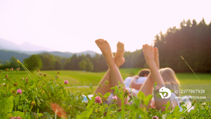 CLOSE UP, DOF: Cinematic shot of young couple lying in the idyllic countryside.