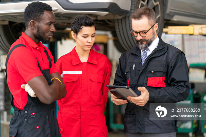 Manager advising the new employees in garage background business concept