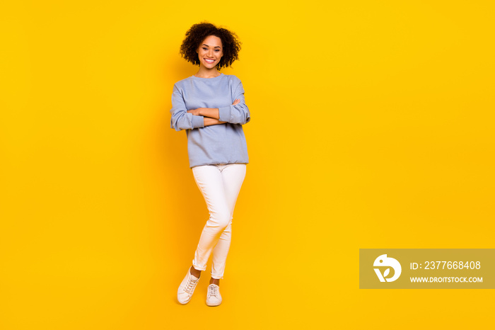 Full size photo of pretty cheerful girl folded arms empty space promotion ad isolated on yellow color background