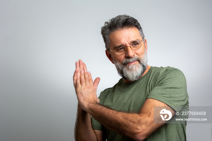 Mature handsome charming man showing something with index finger, place for text, advert, copy space. isolated on blue background. direction. body language. sale, shop