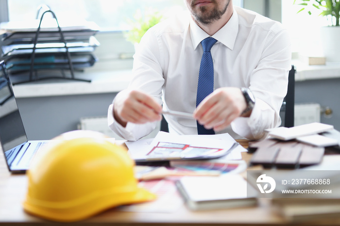 Male architect designer is sitting at his work table