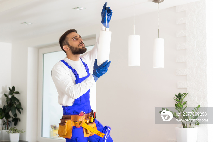 electrician installing led light bulbs in ceiling lamp