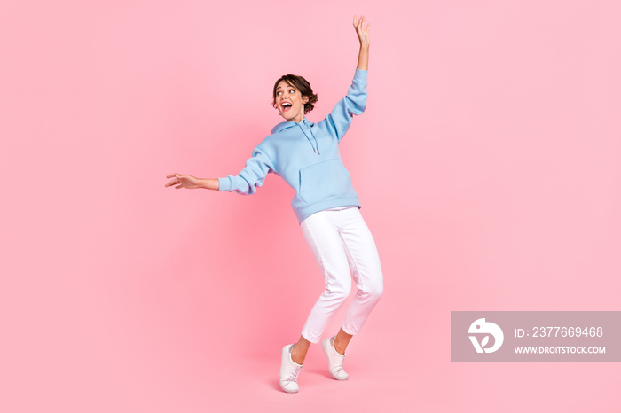 Full body photo of cheerful lady dressed stylish blue clothes stand toes interested look empty space isolated on pink color background