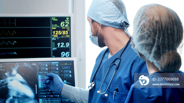 Professional medical doctors working in emergency medicine. Portrait of the surgeon and the nurse in protective masks performing surgical operation.